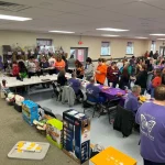 Another view of the line of people getting t-shirts and basket raffle tickets at the Breaking the Silence Mystery Bingo.