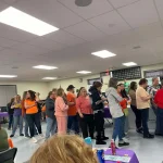 People waiting in line to check out the baskets at the Breaking the Silence Mystery Bingo.