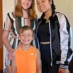 Rianna dressed for her dance recital, posing with her sister and brother.