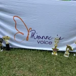 A few trophies sitting on the ground in front of our logo.